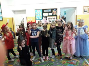 Dziewczynki z klasy I a pozują w strojach karnawałowych wróżek, czarownic, księżniczek, Czerwonego Kapturka, tygryska, złodziejki i Myszki Miki