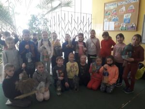 Uczniowie klasy I a prezentują wykonane z recyklingu karmniki