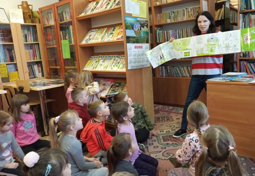 Bibliotekarka pokazuje pierwszakom różne formy książek dla dzieci.