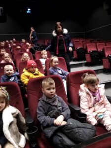 Dzieci siedzące na fotelach w kinie