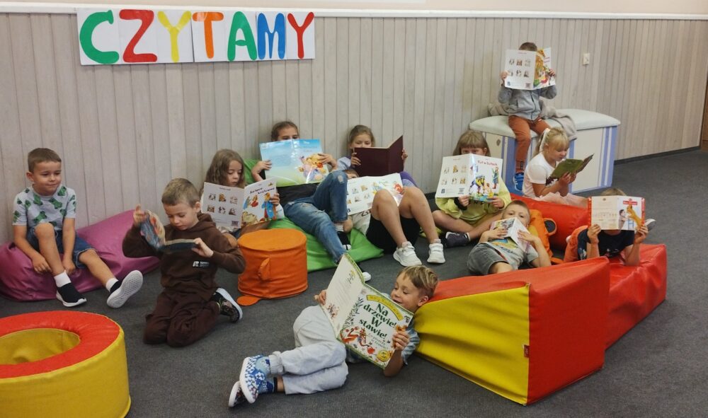 Grupa uczniów czytających książki w świetlicy szkolnej
