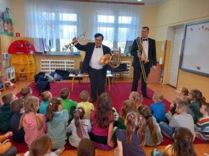 Panowie z filharmonii prezentują różne instrumenty