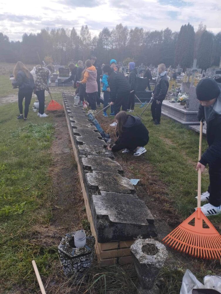 Młodzież szkolna sprząta zapomniane groby
