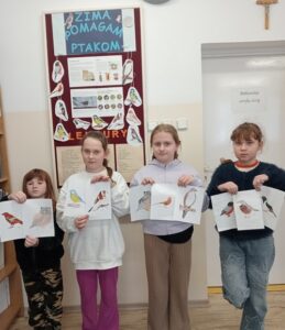 Dzieci trzymają swoje prace przed sobą.